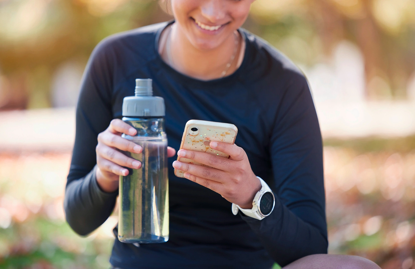 Bild einer Frau mit Wasserflasche und Smartphone